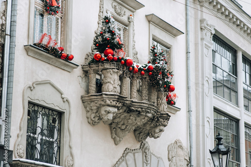 Foto Balcony with caryatids in the form of lion heads and Christmas toys with fir branches
