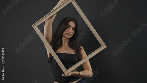 Foto Woman holding an empty frame, creating a portrait with a conceptual focus on art