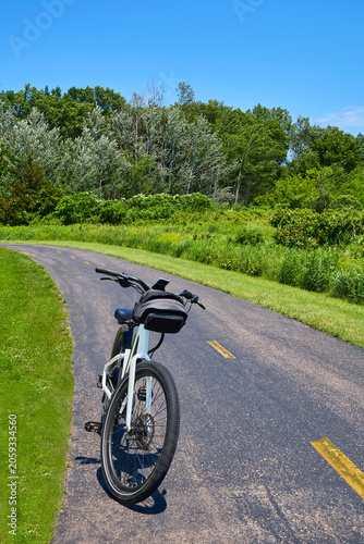 Electric bicycle parked on a paved bike path and ready for a fun ride as a vertical image