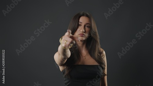 Foto Young woman confidently pointing a finger forward, making an accusatory gesture