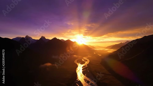 Stunning Sunset Over Mountain Valley with River Flowing Through Golden Light.