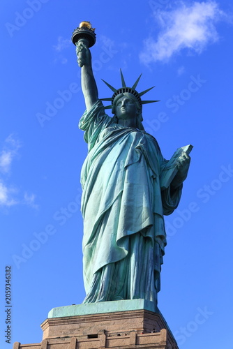 Vertical Low-Angle Shot of the Statue of Liberty Under Intense Blue Sky in New York City