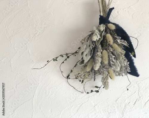 Quadro su tela Dried flower swag on white plaster wall with copy space