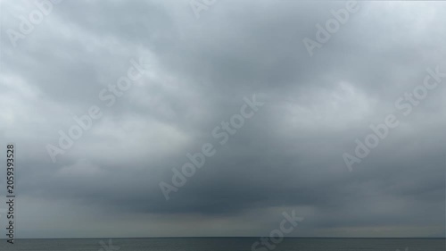 大きな雲と穏やかな水平線が広がる曇り空の海の風景