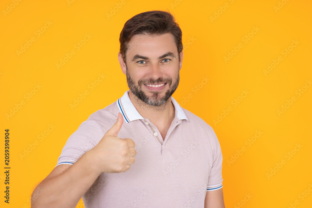 Obraz premium Thumbs up man shows satisfied expression. Thumbs up portrait with casual style. Thumbs up gesture means positive recommendation. Thumbs up concept for communication and feedback.