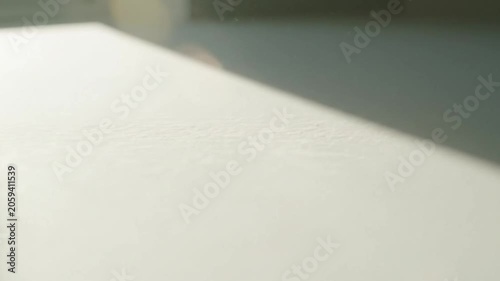Close up of a textured white surface with a diagonal shadow creating a minimalist abstract background with soft lighting