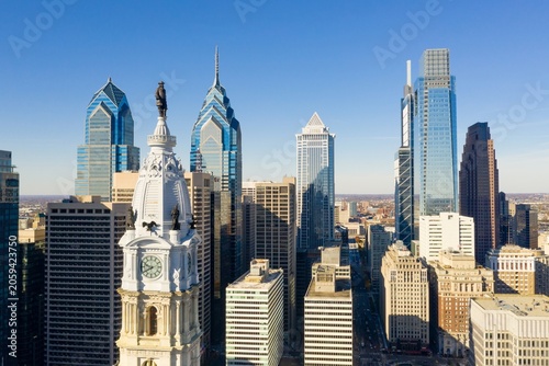 Φωτογραφία Close-up aerial view of Philadelphia City Hall and the downtown skyline, highlighting the William Penn statue, iconic skyscrapers, and modern urban architecture under clear blue skies
