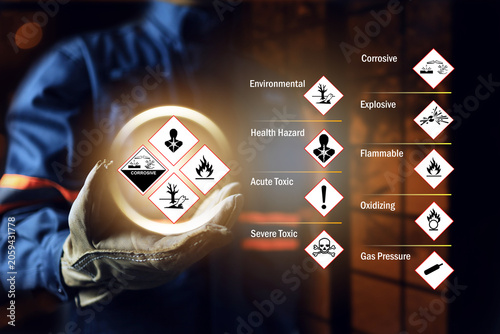 Materials safety data sheet concept with safety staff wearing leather glove holding GHS globally harmonized safety chemical hazard sign to warning in working site