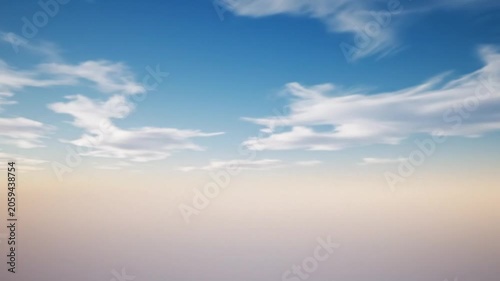 Vast expanse of a clear blue sky with wispy white clouds and a soft gradient horizon at sunrise