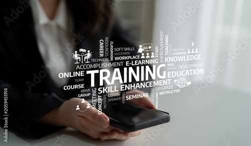 Foto A close-up image of a person holding a smartphone surrounded by concepts of training and skill enhancement, representing the world of online education and personal development