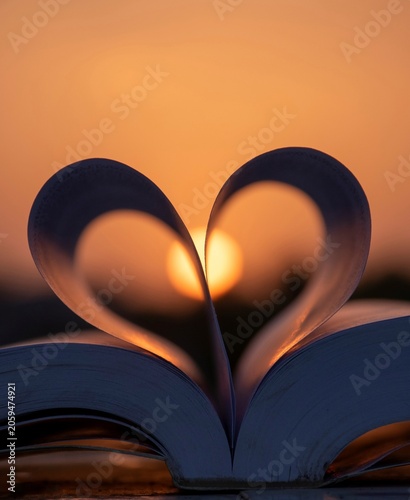 Konstfotografi Evocative open book with heart shaped pages at sunset inspiring educational corp