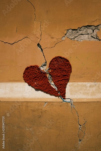 Conceptual corporate risk management banner with knitted broken heart stitched on cracked wall inspiring financial crisis response and business recovery design