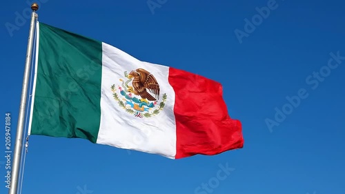 Mexican flag waving against a clear blue sky