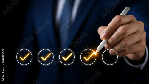 Businessman's hand marking checklist with glowing checkmarks on digital screen during business planning