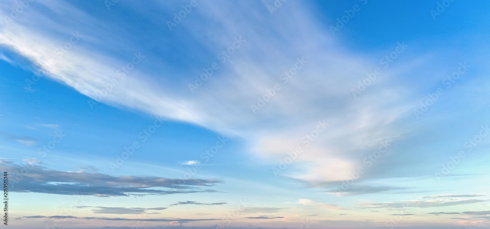 Fototapeta premium Soft clouds drift across a vast blue sky