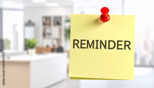 Yellow adhesive memo pad with reminder text attached to office wall reminder business communication information planning