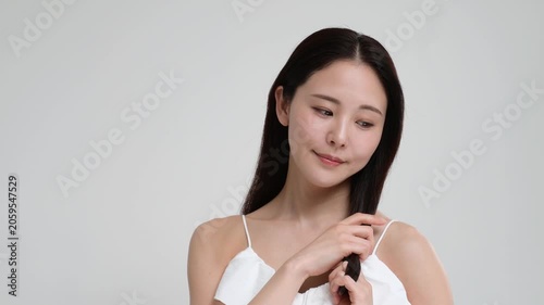 髪の毛を触って笑顔の日本人女性
