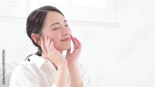 笑顔で肌を触る日本人女性