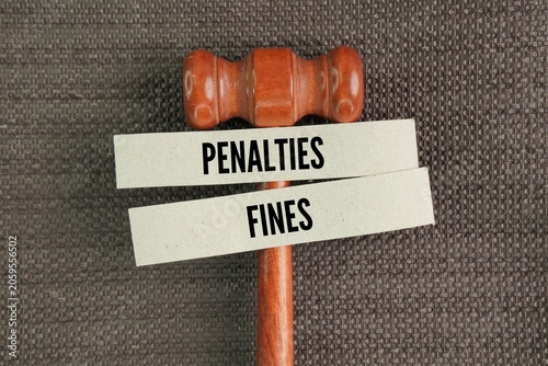 Judge's gavel and paper with the words penalties and fines. operate under the principle of prompt payment to encourage compliance. Failure to settle payments