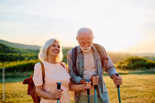 Senior couple enjoying an outdoor hike with trekking poles  embracing health and wellness during golden years