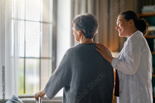 Caring Female Doctor Supporting Senior Patient at Home