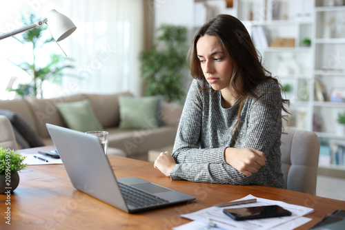 Foto Insecure and depressed teleworker complaining alone at home