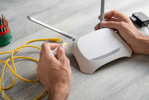 Принти на полотні Caucasian man repairing wifi router. Internet. Technology