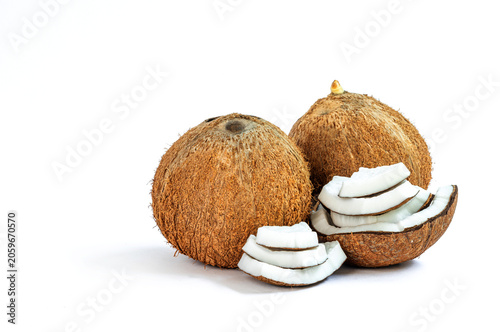 Whole mature coconut and multiple sliced halves on white background, Coconut, showing thick white flesh and brown shell, ideal for food, health, and natural ingredient concepts