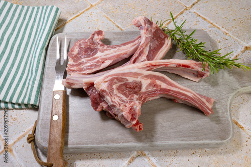 côtes d'agneau crues sur une planche à découper