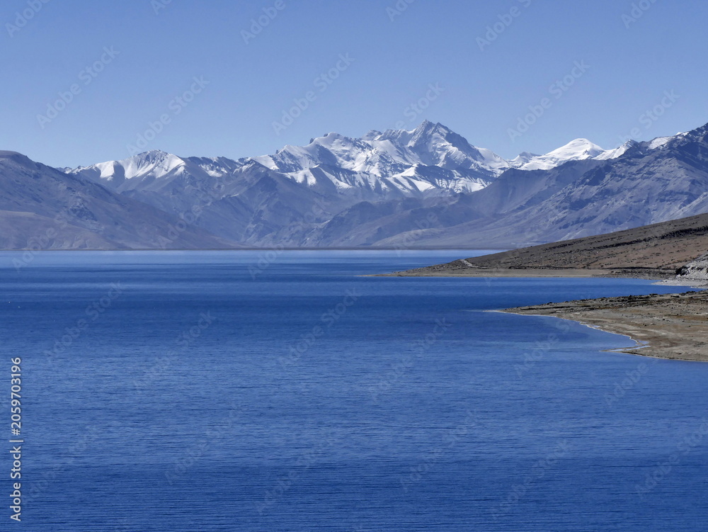 Fototapeta premium Snowcapped mountain peak across tso moriri lake in Ladakh. Himalayan background with copy space