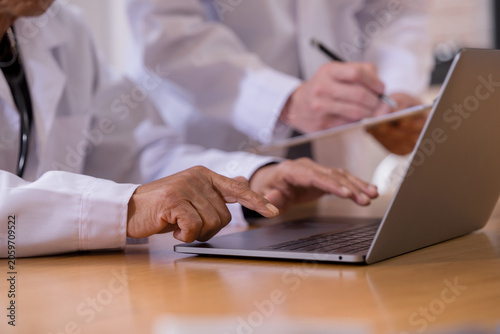 Doctors reviewing and documenting patient records during a medical consultation in a healthcare clinic Professional healthcare team collaborating on diagnosis, treatment planning clinical 
