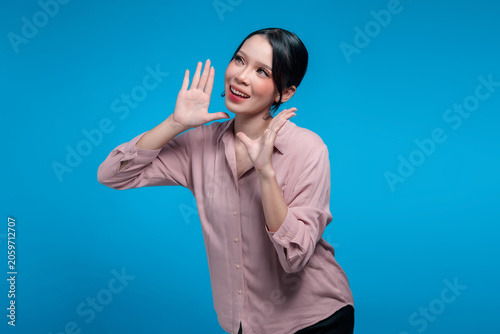 Cheerful Indonesian woman calling out with hands near face