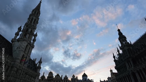 Grand Place Belgium sunset. Low-angle 4K video looking up at the majestic Gothic tower of the Brussels Town Hall between historic guild houses in the famous Grand Place market square.