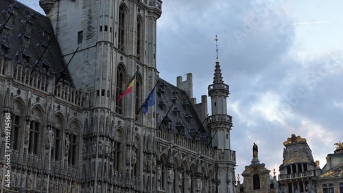 Grand Place Belgium sunset. Low-angle 4K video looking up at the majestic Gothic tower of the Brussels Town Hall between historic guild houses in the famous Grand Place market square.