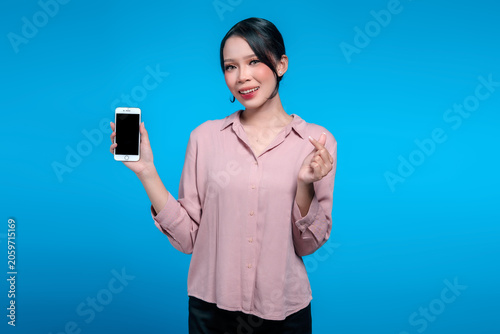 Smiling Asian Woman Holding Blank Smartphone Screen and Making Finger Heart