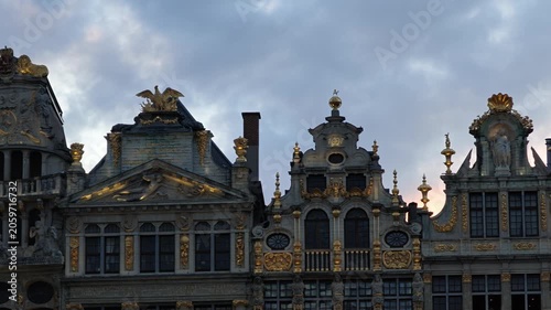 Grand Place Belgium sunset. Low-angle 4K video looking up at the majestic Gothic tower of the Brussels Town Hall between historic guild houses in the famous Grand Place market square.