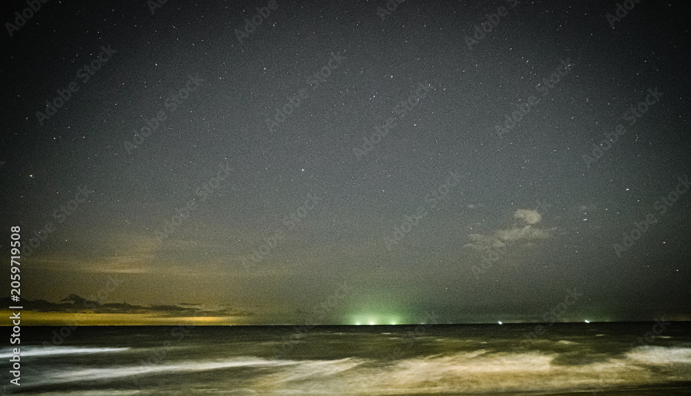 Fototapeta premium Starry Night Sky Over Long Exposure Ocean Waves