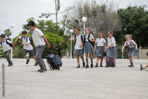 Foto Group of elementary school children running and playing in the school courtyard