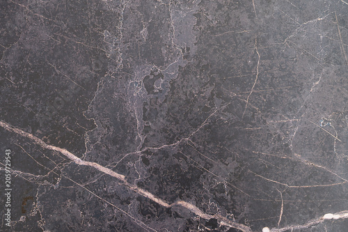 Dark marble slab with pale veining on textured surface