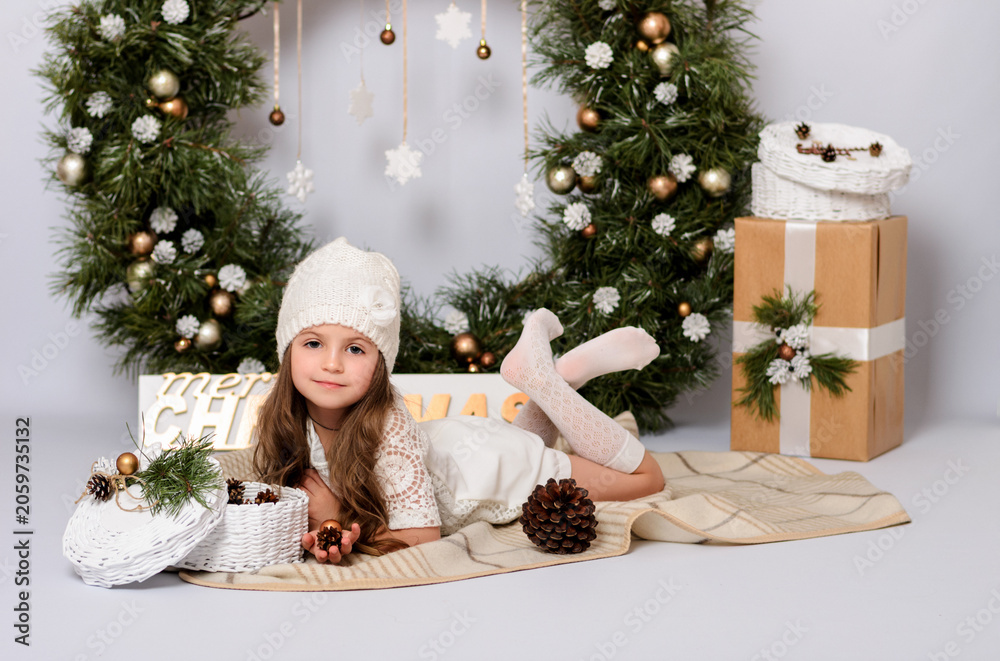Fototapeta premium Christmas celebration. Cute little girl in a beautiful dress on Christmas. Happy New Year.