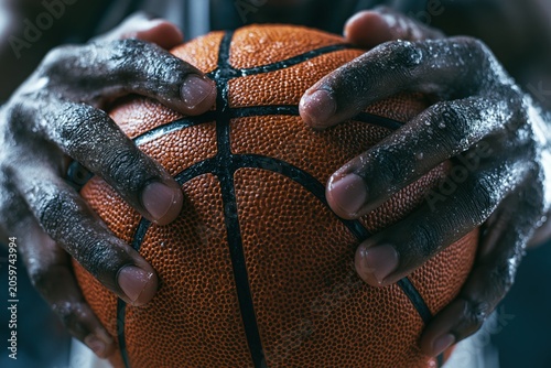 Athlete's wet hands gripping basketball showing determination and effort