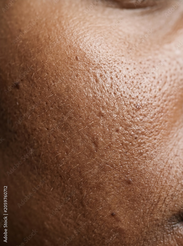 Fototapeta premium Extreme close up of healthy dark skin texture showing natural pores and complexion.