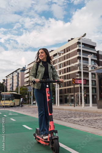 Woman riding electric push scooter in city