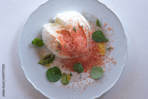 Fresh buffalo mozzarella with grated frozen tomato and herbs, gourmet Italian summer recipe 
