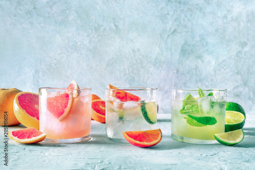 Refreshing summer cocktails with ice cubes on a light background