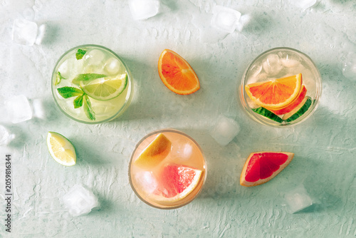 Refreshing summer cocktails with ice cubes on a light background