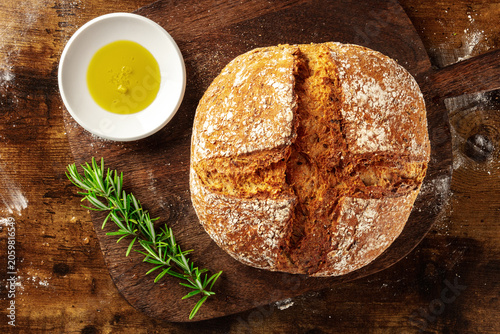 Homemade artisan sourdough bread loaf on a rustic wooden cutting board