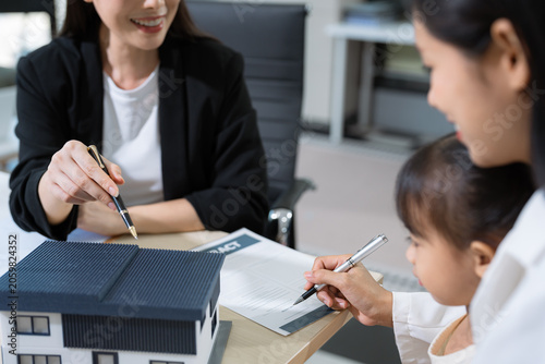 Foto Real estate broker agent presenting and consult to customer to decision making sign insurance form agreement, home model, concerning mortgage loan offer in office