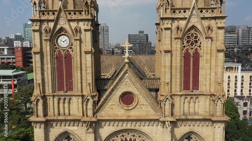 Rising drone shot past beautiful historic Sacred Heart Cathedral reveals skyline of downtown Guangzhou in China