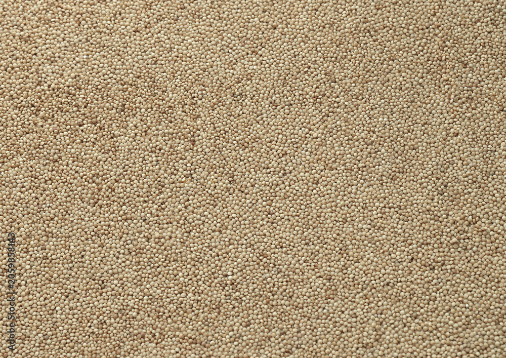 Fototapeta premium Dry amaranth grains in big pile on table close up. Large amount of yellow amaranth grains